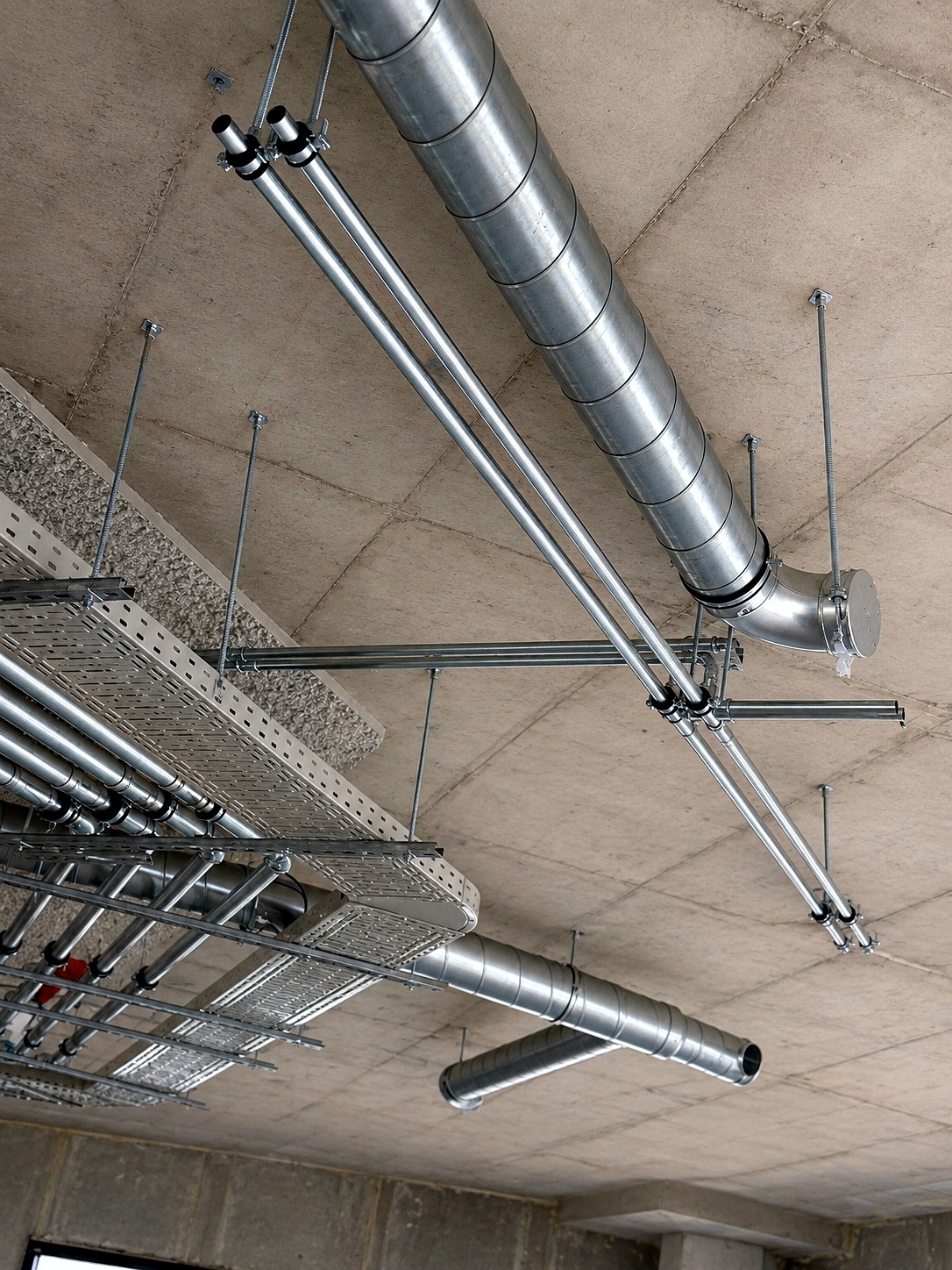 Verzinkt kanaal- en leidingwerk onder een betonplafond